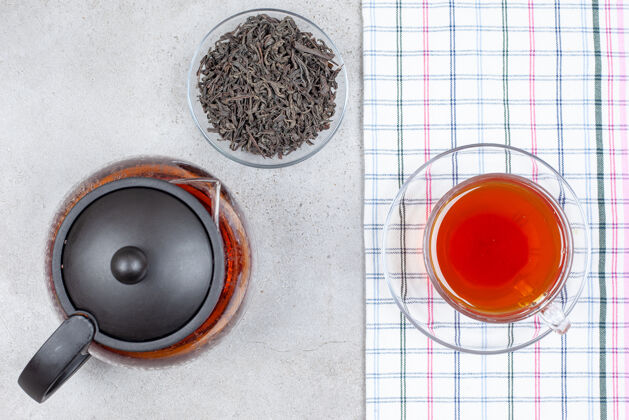 美味一个茶壶和一小碗茶叶旁边的一杯茶毛巾上的大理石背景高品质的照片茶壶新鲜芳香