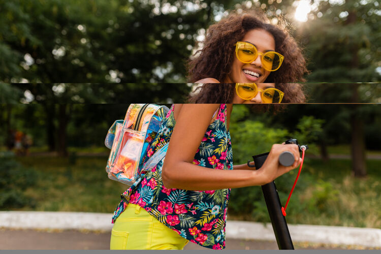 人年轻时尚的黑人女子在公园里玩得很开心骑着电动脚踏车在夏天的时尚风格 五颜六色的时髦服装 穿着背包和黄色太阳镜酷欢呼积极