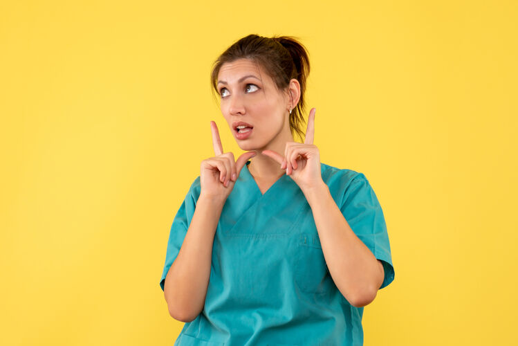黑发前视图黄色背景上穿着医用衬衫的女医生医疗病毒护士