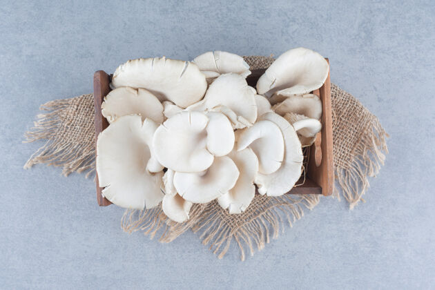 新鲜装满牡蛎蘑菇的木箱放在袋子上配料健的