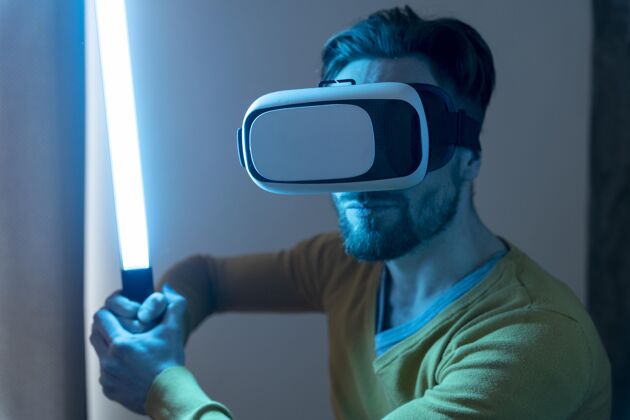 休闲男人用虚拟现实耳机玩激光剑虚拟现实虚拟现实水平