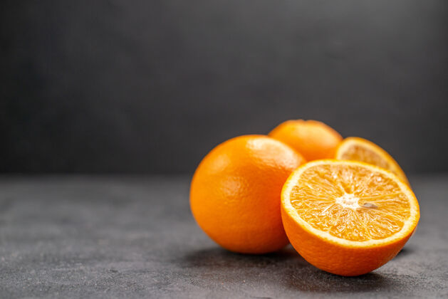 脐橙黑暗的桌子上新鲜的整片柠檬和切片柠檬的水平视图多汁整个橙子