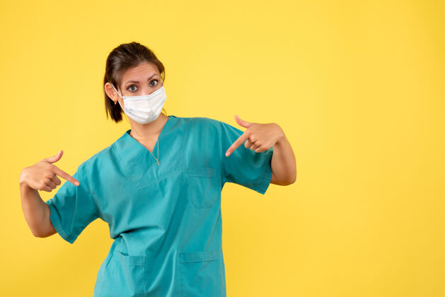 衬衫正面图黄色背景上穿着医用衬衫和无菌口罩的女医生女医生正面人