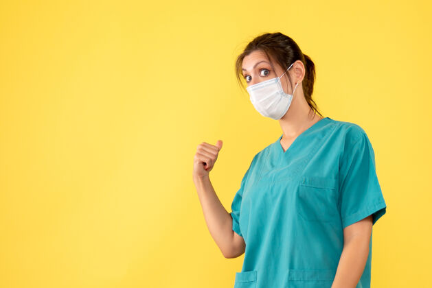 视图正面图黄色背景上穿着医用衬衫和面罩的女医生医疗磁盘骑师人