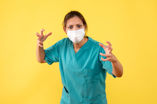 肖像前视图黄色背景上穿着医用衬衫和面罩的女医生健康人脸