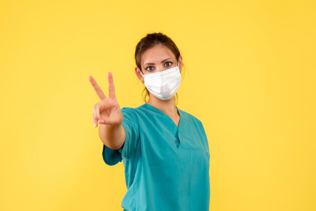 正面正面图黄色背景上穿着医用衬衫和面罩的女医生面具女医生病毒