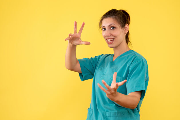 护士正面图黄色办公桌上穿着医用衬衫的女医生科维德医院彩色护士健康病毒医生健康微笑黄色