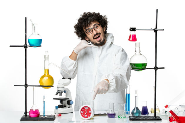 化学正面图身着白色特别套装的年轻男科学家摆姿势视图大流行烧杯