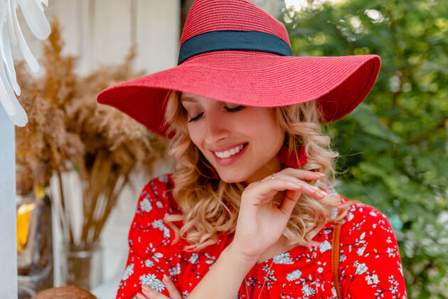 配饰近距离拍摄迷人的时尚金发微笑的妇女在稻草红色帽子和衬衫夏季时尚装微笑性感的肖像明亮装束年轻
