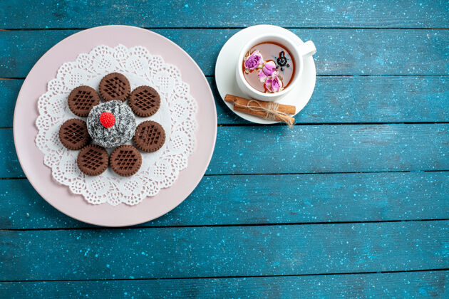 杯子俯瞰美味的巧克力饼干和一杯茶在蓝色的乡村办公桌饼干茶饼干甜蛋糕糖蛋糕巧克力瓷器