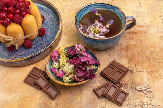 碗近距离观看一杯热花草茶软蛋糕与水果和鲜花巧克力香薰杯子食物