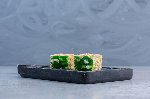 风味绿色土耳其语愉快的大理石背景上的一个小董事会颜色美味甜点