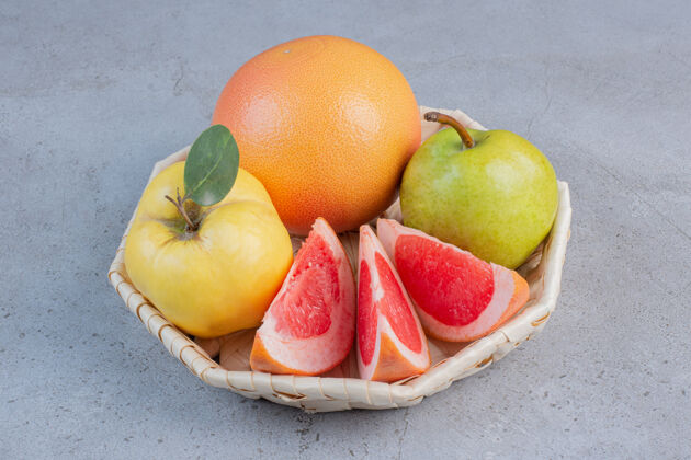 梨一小包水果放在大理石背景的白色篮子里营养木瓜天然