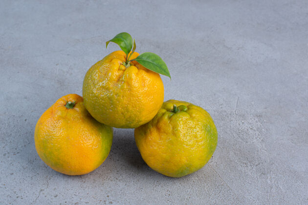 美味大理石背景上陈列着一束多汁的橘子美味天然健康