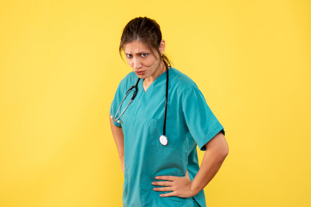 护士前视图黄色背景上穿着医用衬衫的女医生视图专业女医生
