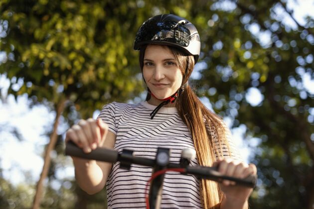 城市一个年轻女子在公园里骑着电动滑板车滑板车科技快速