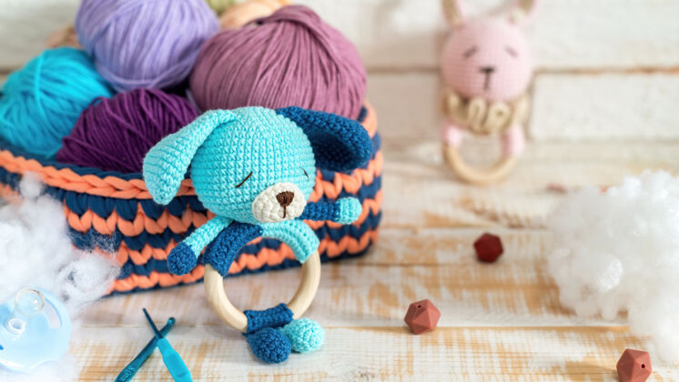毛皮可爱的针织毛绒玩具和五颜六色的纱线球在针织沙发与毛绒周围有趣娃娃天