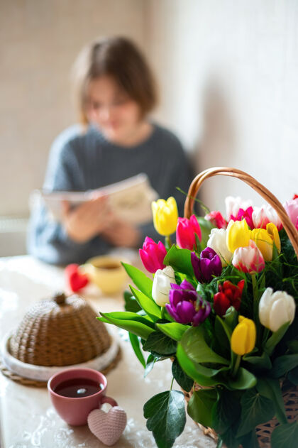 家庭一束鲜花和一个女孩在桌上写字厨房室内烹饪花束