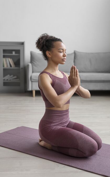 瑜伽健身女士在家里用瑜伽垫做瑜伽平衡灵活姿势
