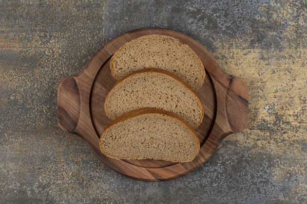 糕点美味的黑面包片放在木板上黑麦晚餐早餐