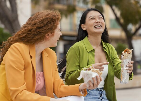 美味快乐的女人一起吃街头美食女性顾客城市