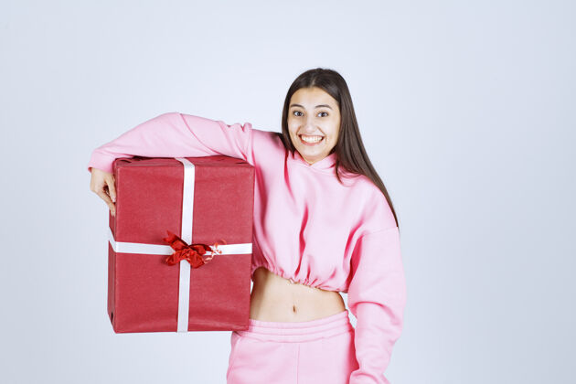 人体模特穿着粉色睡衣的女孩抱着一个大大的红色礼盒 微笑着人模特照片