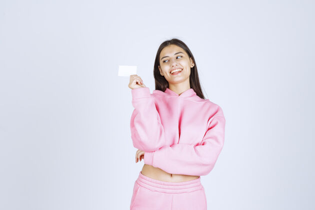 人体模特穿着粉色睡衣的女孩拿着名片向她的商业伙伴介绍自己服装晋升女人