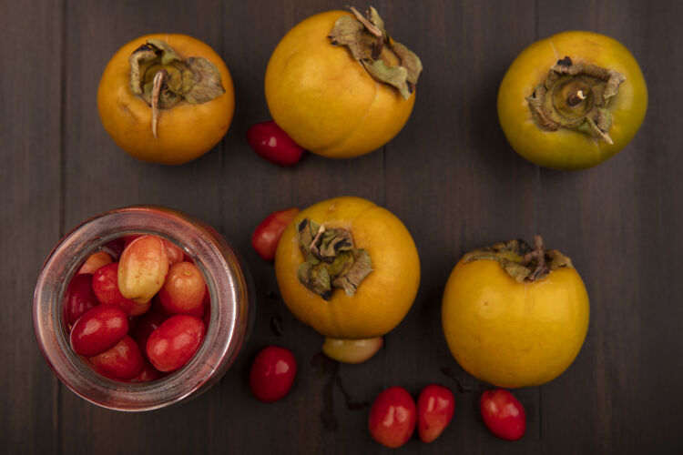 玻璃顶视图美味的红凤梨樱桃在一个玻璃罐柿子水果隔离在一个木制表面樱桃配料食品