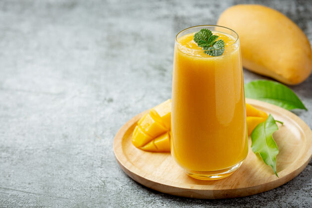 混合芒果汁在黑暗的玻璃表面水果特写玻璃