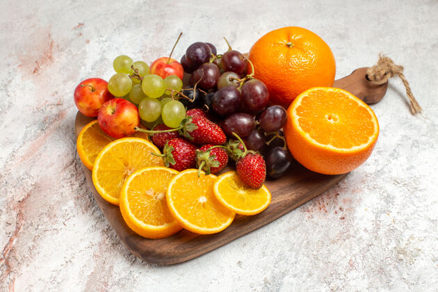 多汁前视图新鲜水果组成橘子葡萄和草莓上的白色空间橙子柑橘葡萄