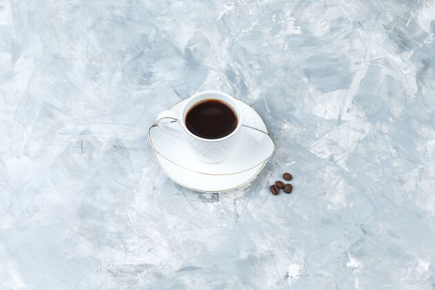 桌子蓝色大理石背景上的咖啡杯高角度视图卡布奇诺早餐食物