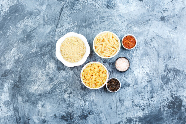 午餐顶视图在灰色灰泥背景上用香料盛在碗里的什锦意大利面水平博洛尼亚食物碗