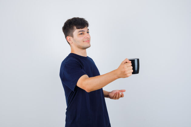 提供穿黑色t恤的年轻人 端着一杯茶 看上去很温柔 正前方的景色在一起茶关系