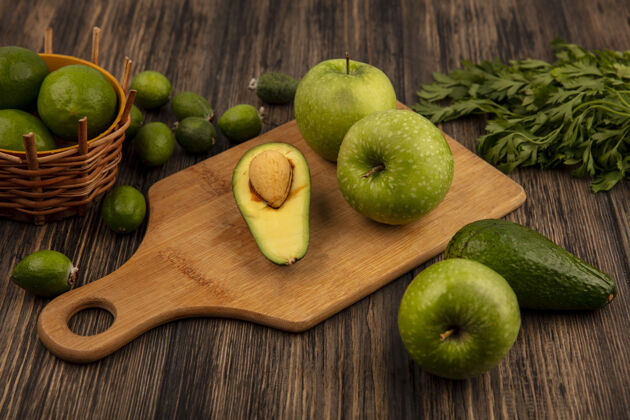 健康木制厨房板上健康苹果的俯视图 桶上放着酸橙 木桶表面隔离着鳄梨和欧芹水果营养木材