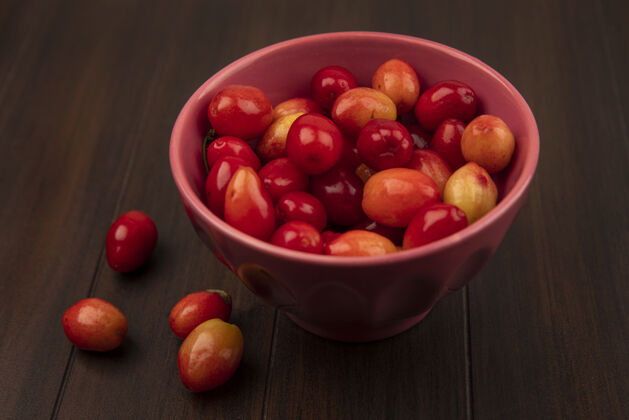 樱桃在木制表面的碗上 浅红色的酸茱萸樱桃的俯视图美味酸木材