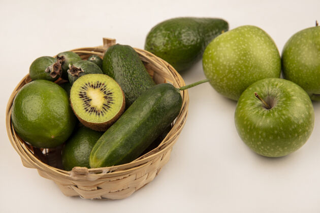 美味新鲜鳄梨的俯视图 黄瓜 酸橙和苹果放在桶上 绿色的苹果被隔离在白色的表面上配料餐素食