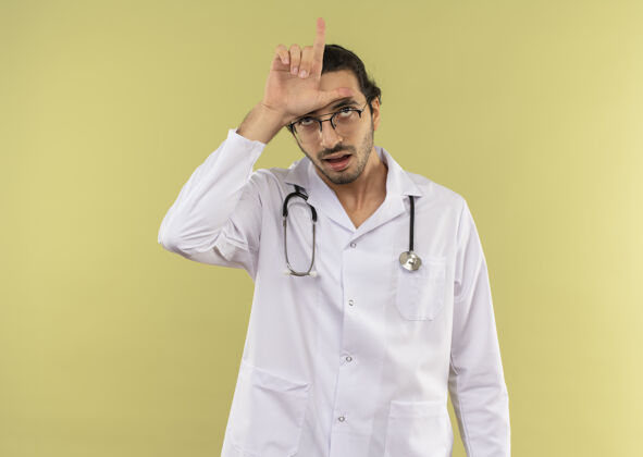 穿戴着眼镜 身穿白袍 手戴听诊器的年轻男医生男性绿色听诊器