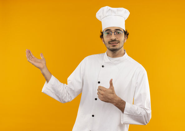 点年轻的男厨师穿着厨师服 戴着眼镜 高兴地用手点着大拇指向上男拇指壁板