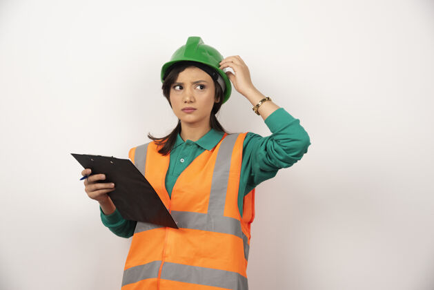 头盔穿着制服的女工业工程师 白色背景上有剪贴板女性个人工人