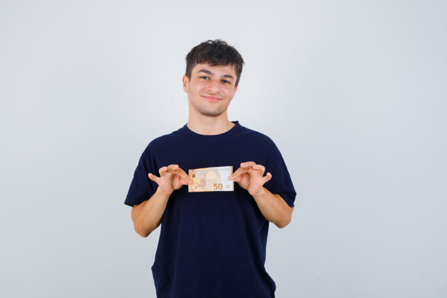 比尔年轻人拿着黑色t恤的欧元钞票 看上去很自信正面图欢呼自信时尚