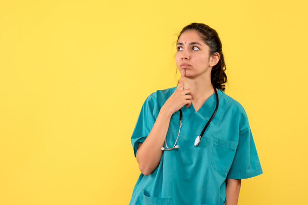 护士前视图体贴的女医生 听诊器将手放在黄色背景上的下巴上成人手思想