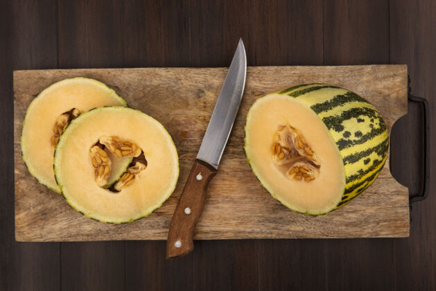 夏天在木制的厨房板上用刀在木制的表面上的新鲜的哈密瓜片的俯视图甜瓜美味美味