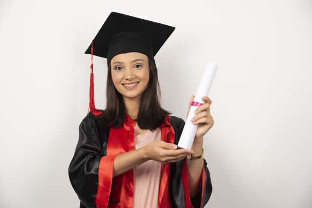 微笑在白色背景上展示毕业证书的女生女性毕业年轻