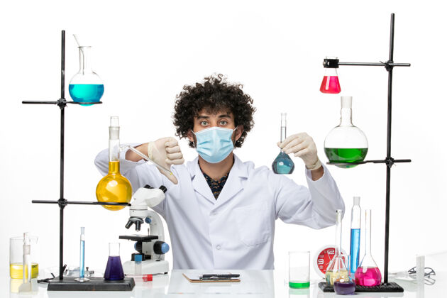 西装正面图男性化学家穿着白色的医疗服 戴着面罩 在白色的空间里拿着蓝色的溶液医生医学医学