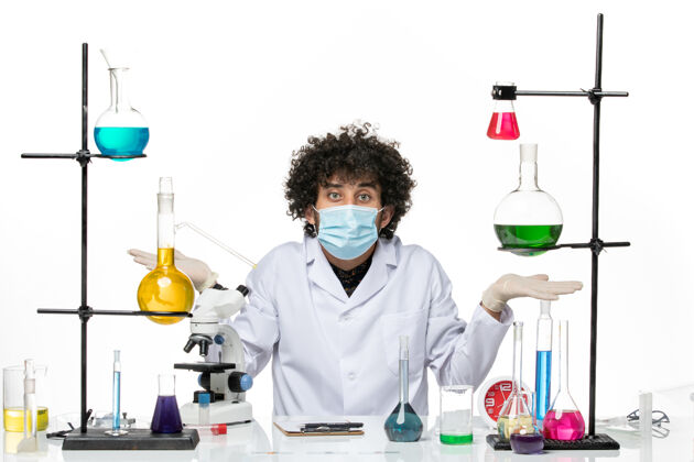 实验室正面图：男化学家 穿着医疗服 戴着面罩 坐在白色的空间里医学实验室外套专业