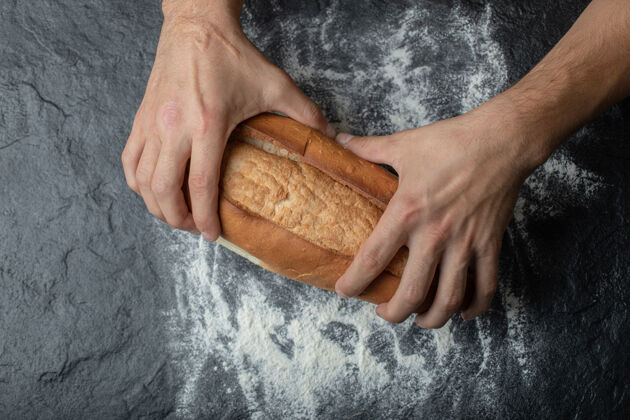 手臂女性手掰新鲜出炉的面包 特写镜头传统食谱自制