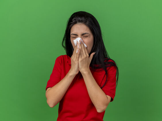 疾病皱着眉头的年轻白种病女孩用餐巾擦鼻子闭着眼睛隔离在绿色墙壁上 留着复印空间餐巾鼻子湿巾