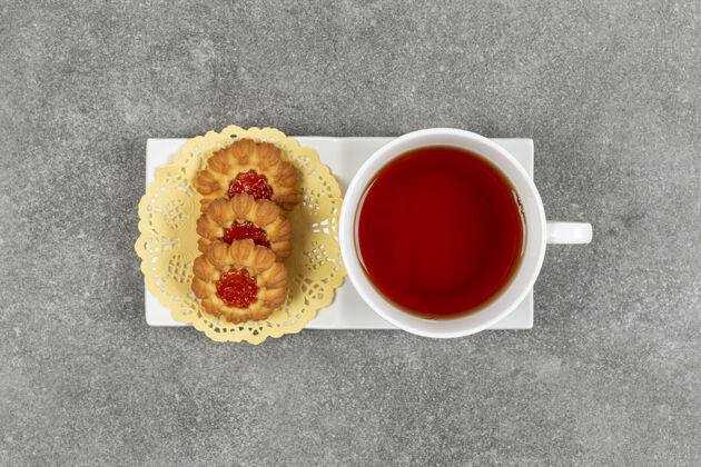 饼干自制饼干加果冻和一杯茶放在白碟子上美味杯子饼干