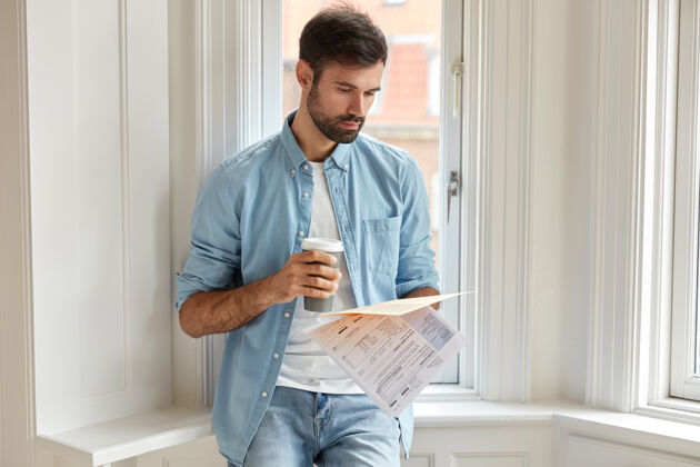 衬衫横拍严重未刮胡子的男子手持打印的统计文件阅读外卖窗台