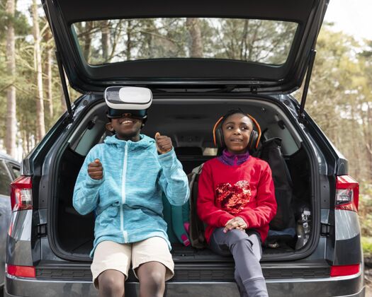 冒险坐在汽车后备箱里的孩子们旅行虚拟现实耳机乐趣